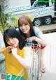 A couple of young women standing next to each other near a shopping cart.