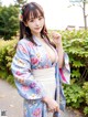 A woman in a blue and white kimono posing for a picture.