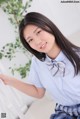 A woman in a blue shirt and plaid skirt posing for a picture.