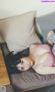 A woman in a pink bikini laying on a couch.