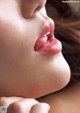 A close up of a woman's lips with her hand on her chin.